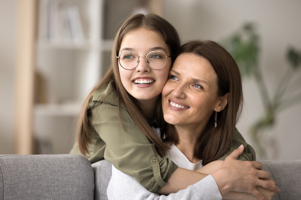 Family Smiling After Dental Care - Complex Comprehensive Dentistry A joyful mother and daughter share a warm embrace, reflecting the lasting results of family-focused dental care and complete oral health – Complex Comprehensive Dentistry.